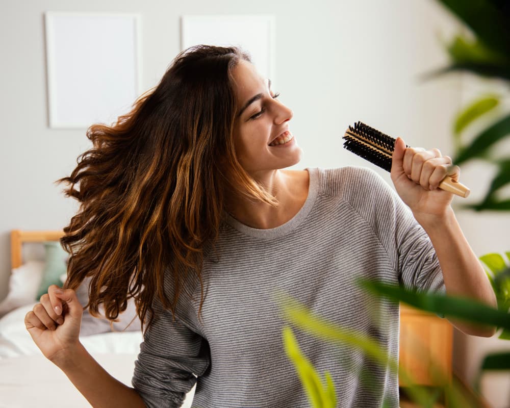 woman singing into hair brush